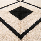 Close-up texture detail of black and ivory wool pile showing hand-knotted construction and depth