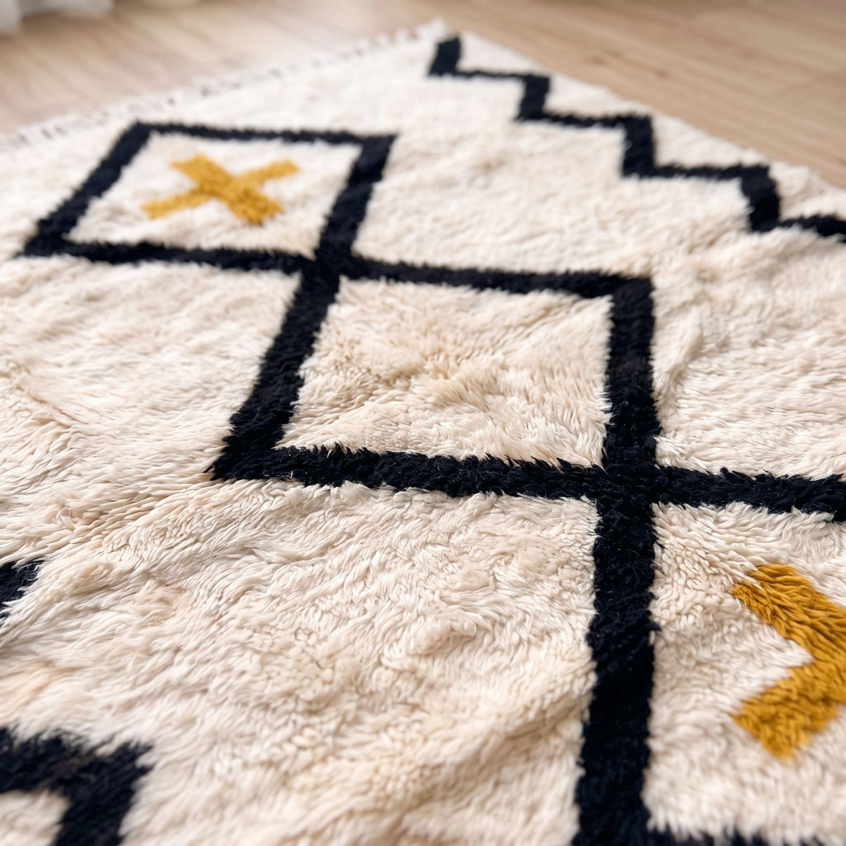 Textured pile detail showing black diamond outline and ivory wool on Beni Ourain rug