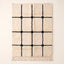 Ivory Beni Ourain rug with black grid lattice and knots, flat lay