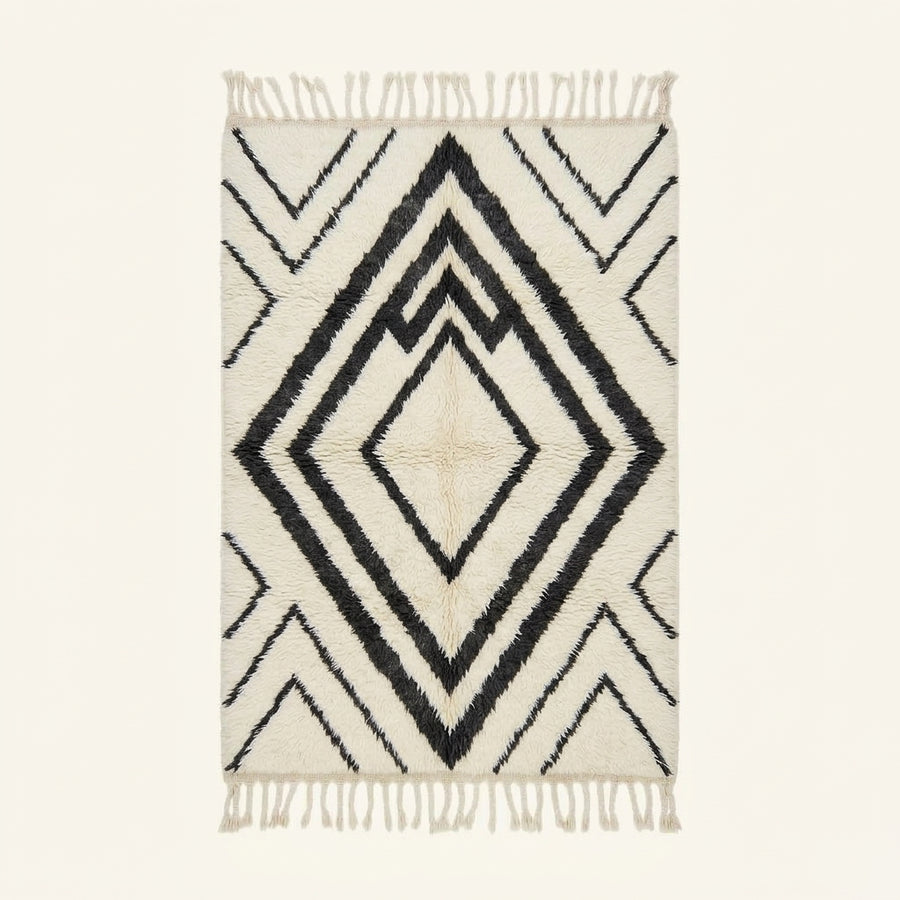 Ivory and black Beni Ourain rug with nested diamond lattice pattern, flat lay on plain background