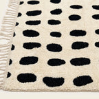 Angled view of the Tissa ivory and black Beni Ourain rug showing the oval grid design.