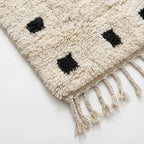 Close-up of the ivory and black wool rug border.