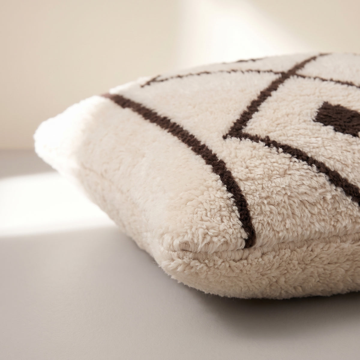 Side view of the Amayas Moroccan pillow showing its ivory and black wool pile