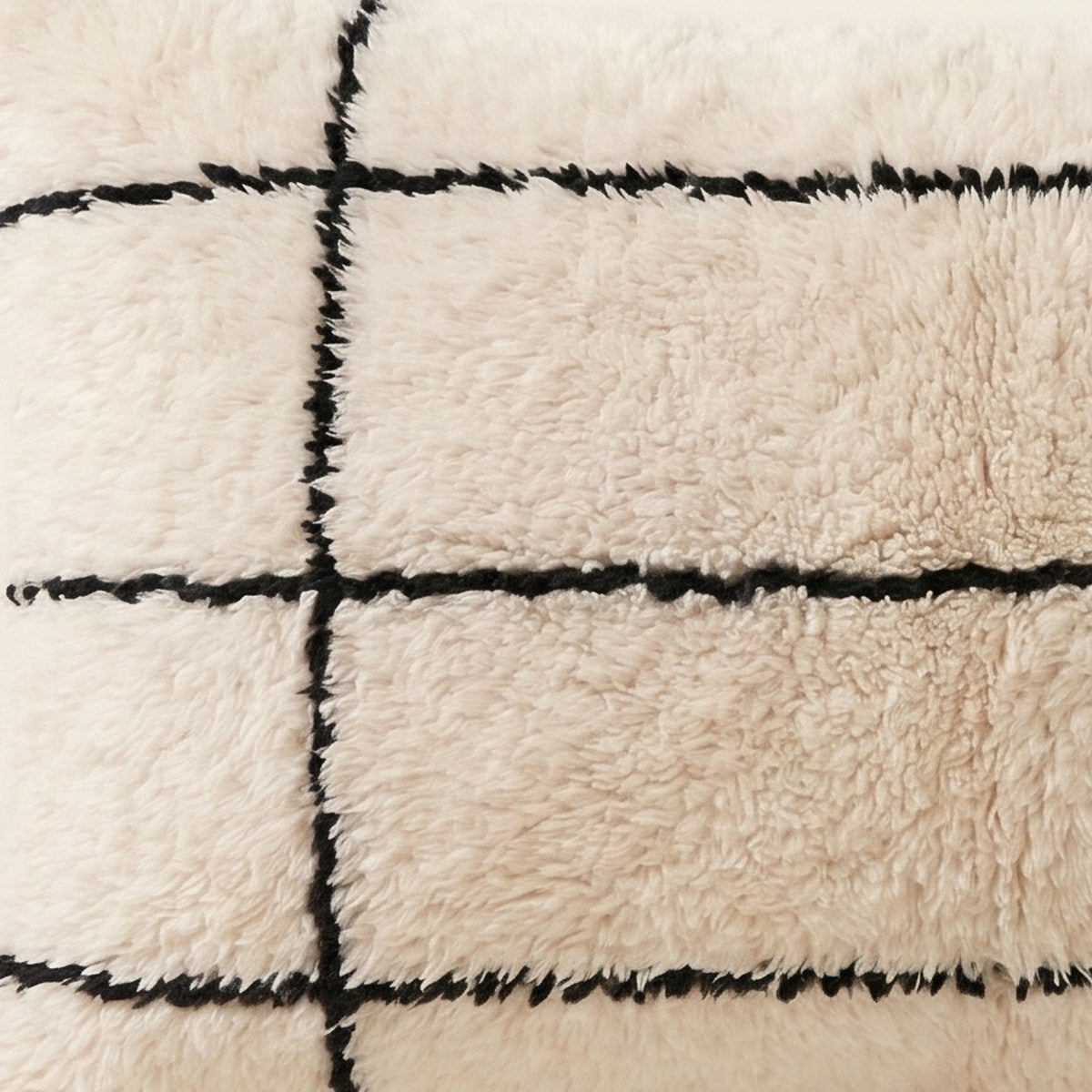 Side view of the Tidi Moroccan pillow showing its ivory and black wool pile