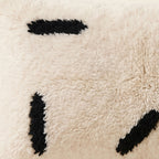 Side view of the Azul Moroccan pillow showing its ivory and black wool pile