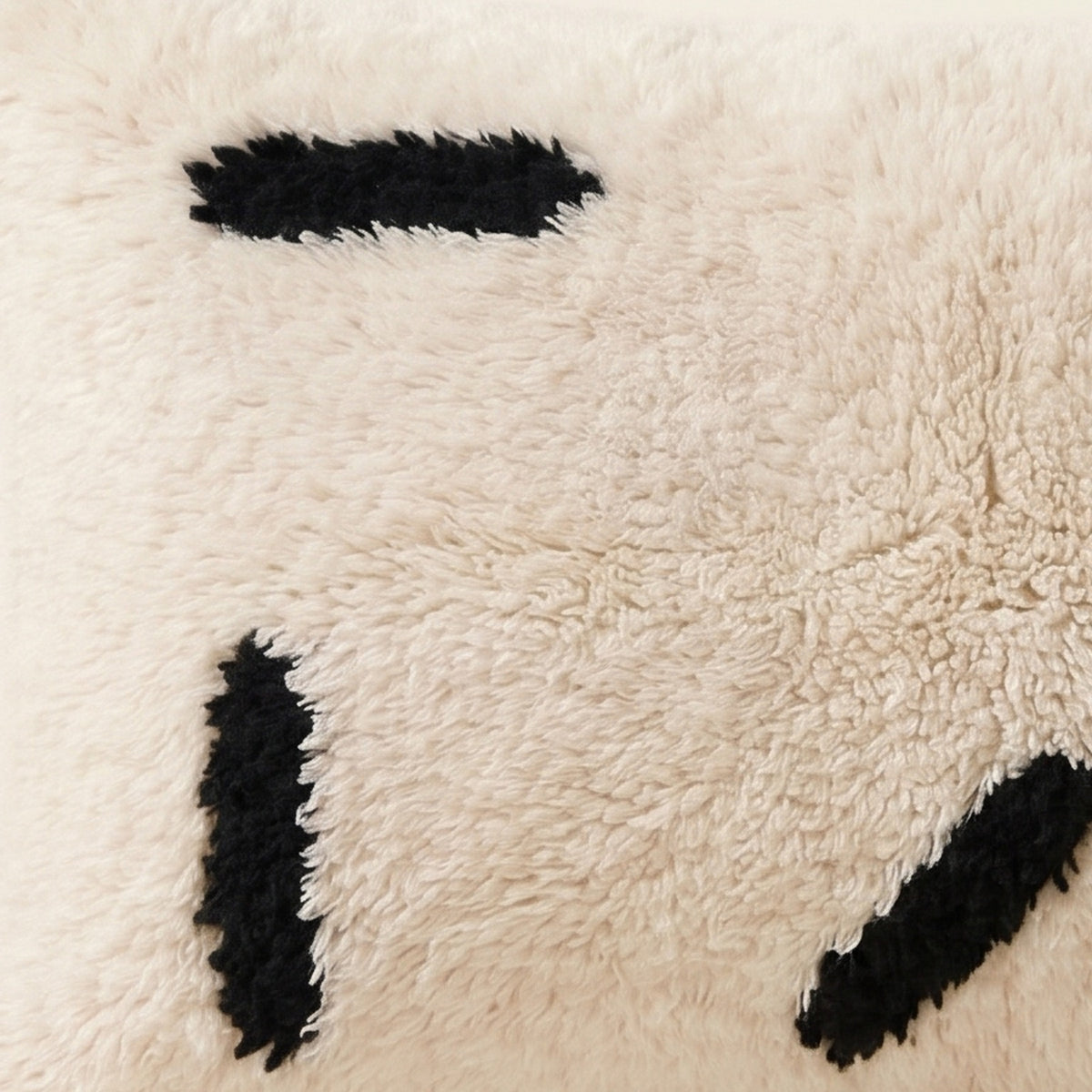 Side view of the Azul Moroccan pillow showing its ivory and black wool pile