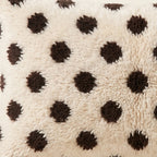 Side view of the Anir Moroccan pillow showing its ivory and black wool pile