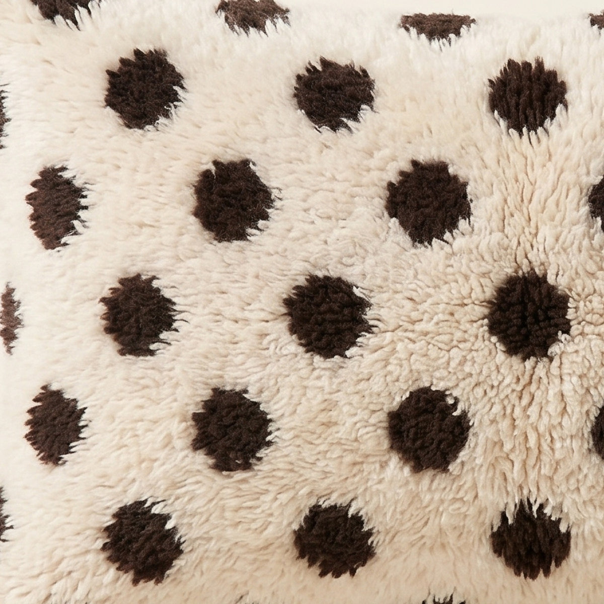 Side view of the Anir Moroccan pillow showing its ivory and black wool pile