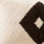 Side view of the Tit Moroccan pillow showing its ivory and black wool pile