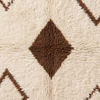 Textured close-up of brown diamond motif with surrounding ivory pile detail