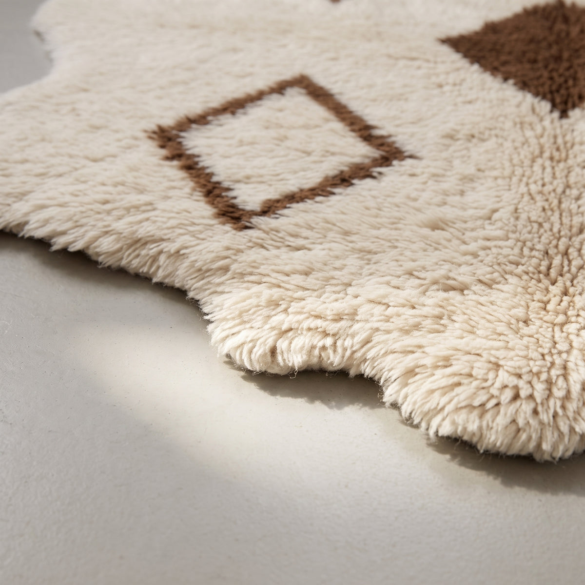 Side angle showing pile depth and fringe edge of ivory Beni Ourain rug