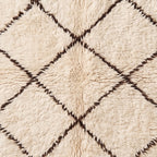 Detailed view of diamond lattice pattern and soft wool texture on Beni Ourain rug Ifri