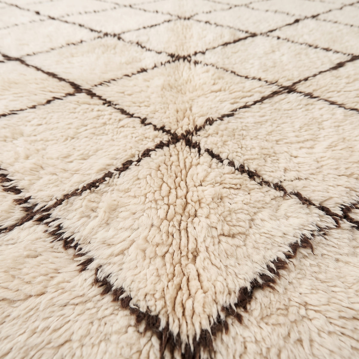 Close-up of thick soft pile and dark brown lattice lines on ivory Beni Ourain rug Ifri