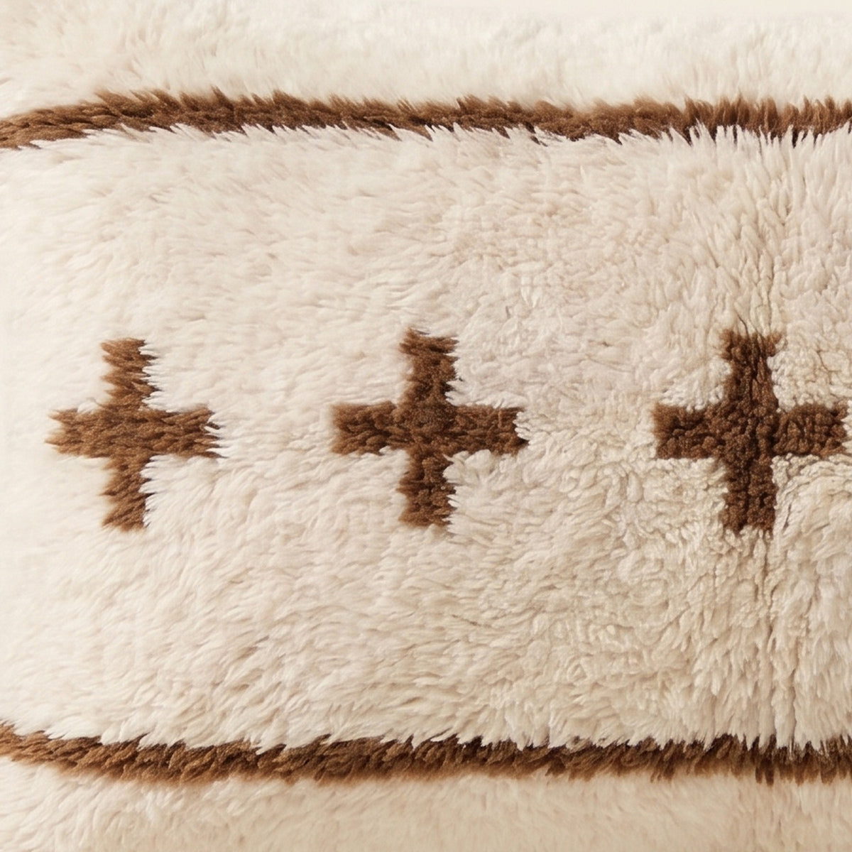Side view of the Tamazgha Moroccan pillow showing its ivory and brown wool pile