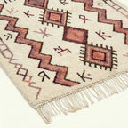 Border and geometric line detail of the ivory and burgundy Akalas Azilal rug