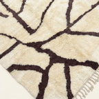 Angled view of the Mazigh ivory and burgundy Beni Ourain rug showing the branch line design.