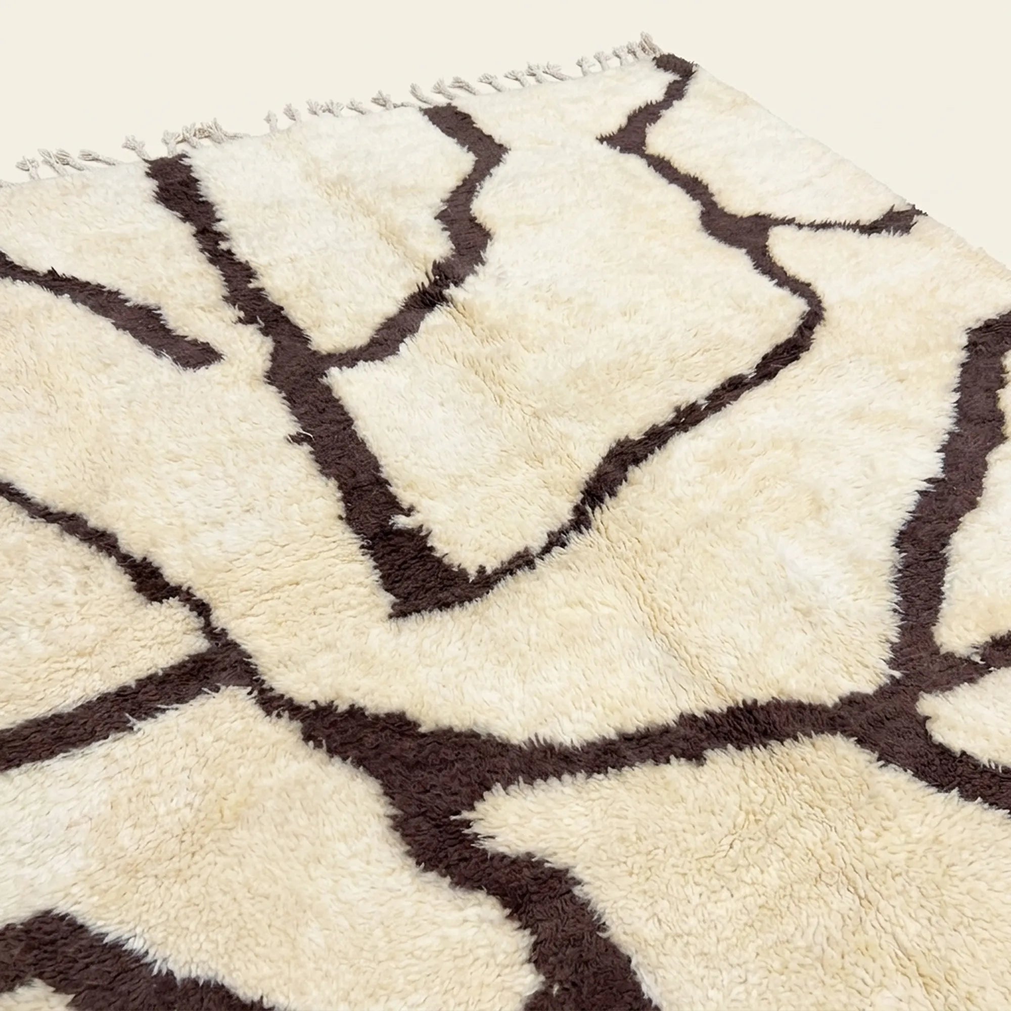 Close-up of the burgundy branch line pattern on the Mazigh ivory Beni Ourain rug.