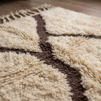 Close-up of the natural Atlas wool pile on the Mazigh ivory and burgundy Beni Ourain rug.