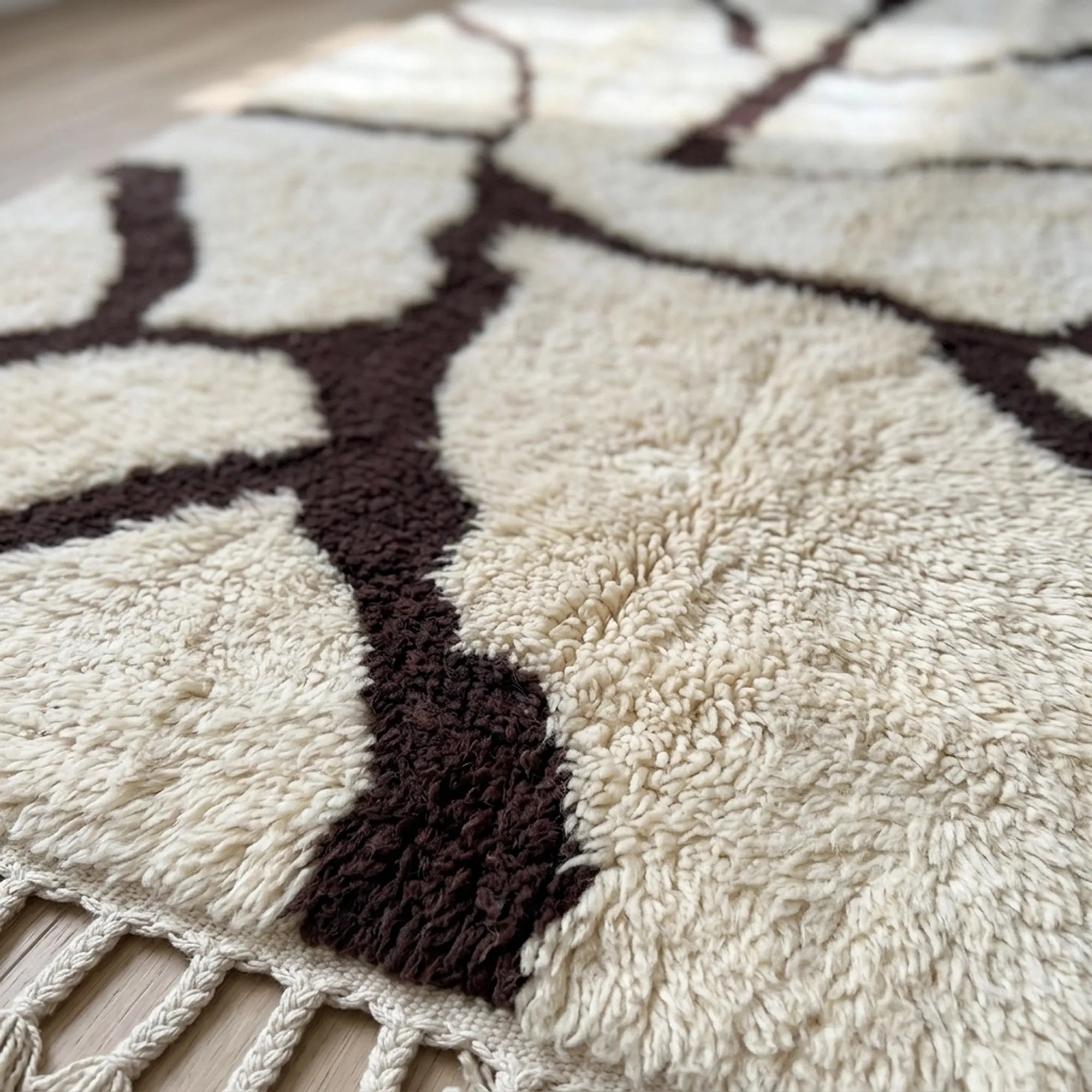 Fringe and hand-finished edge detail of the Mazigh ivory and burgundy Beni Ourain rug.