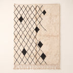 Ivory & Charcoal Beni Ourain rug with black diamond lattice and scattered black diamond accents on plain background