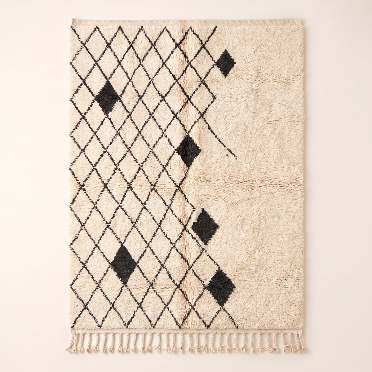 Ivory & Charcoal Beni Ourain rug with black diamond lattice and scattered black diamond accents on plain background