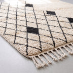Angled detail of Ivory & Charcoal Beni Ourain rug showing depth of wool pile and diamond lattice pattern