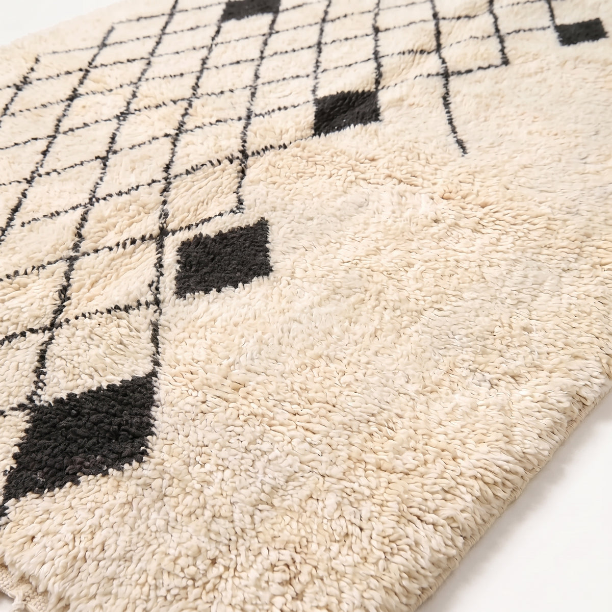 Close-up of Ivory & Charcoal Beni Ourain rug showing thick soft pile and black diamond motifs