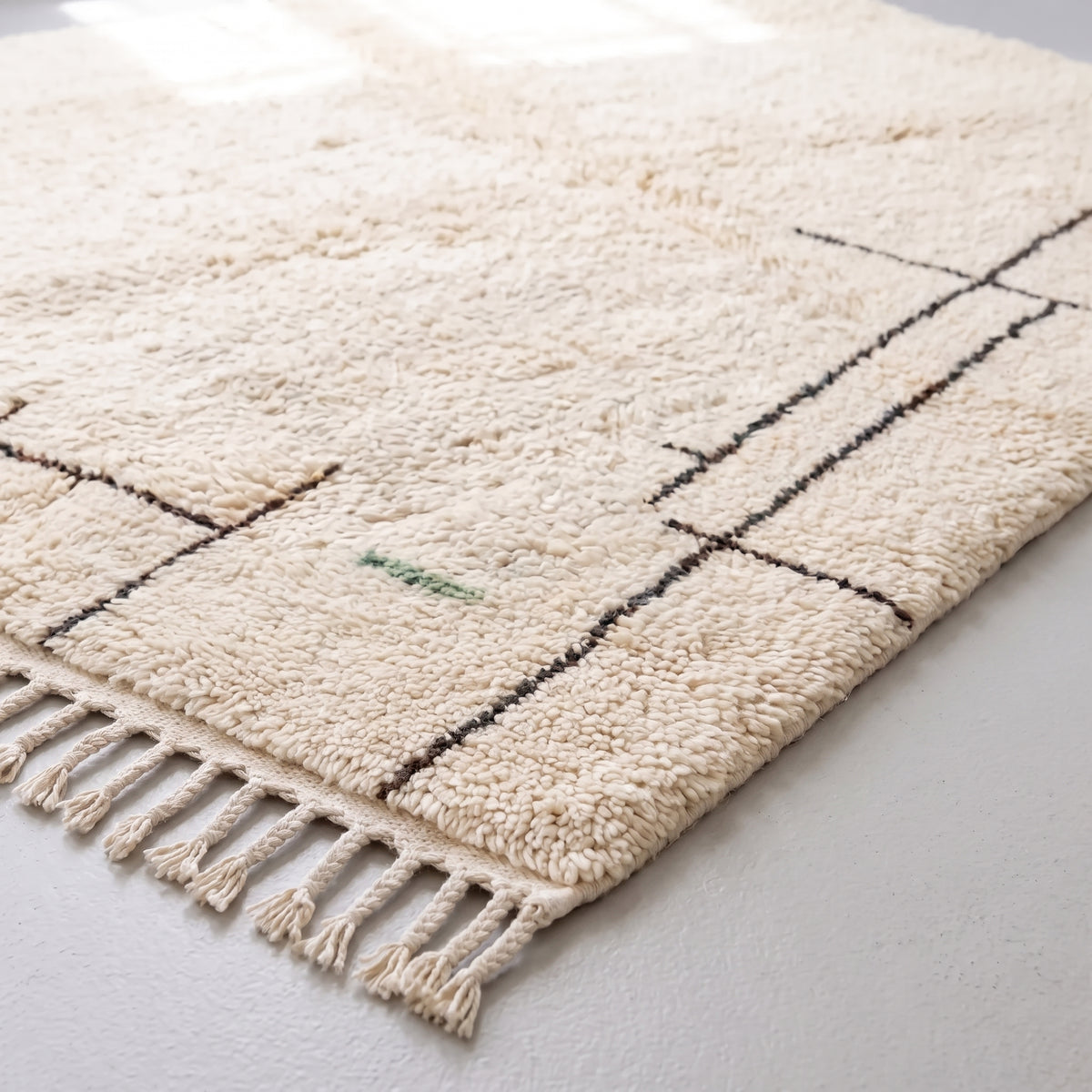 Corner detail showing cream fringe edge and charcoal grid structure