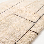 Close-up of soft hand-knotted wool pile showing charcoal grid lines dividing blocks
