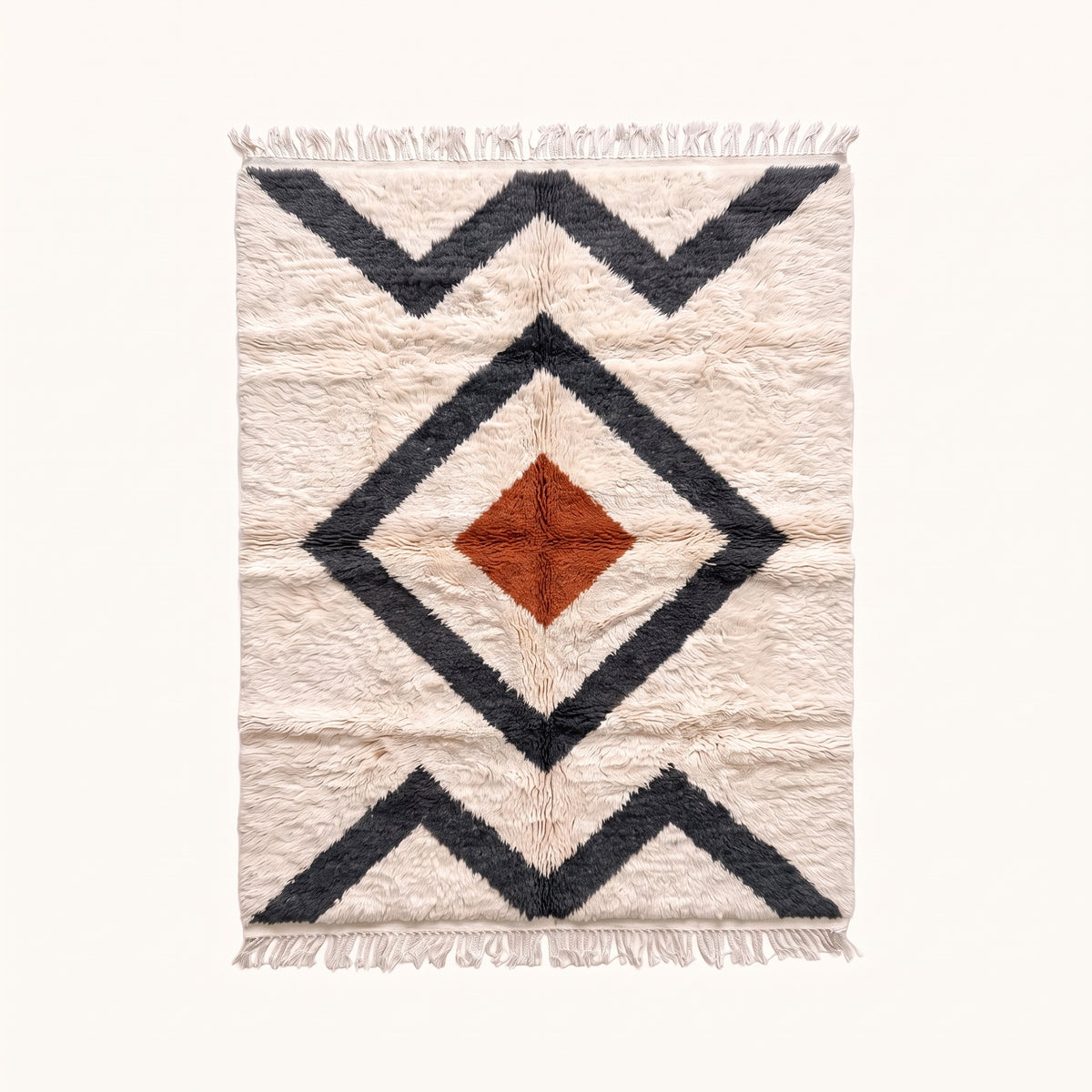 Ivory Beni Ourain rug with nested charcoal diamond borders and terracotta central diamond, flat lay on pale background