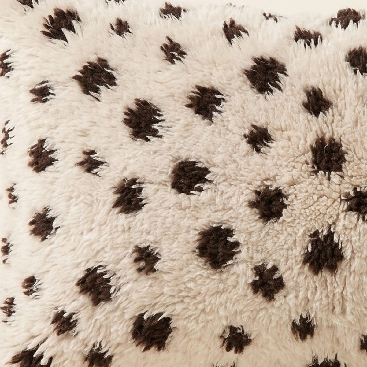 Side view of the Tazzla Moroccan pillow showing its ivory and cocoa wool pile