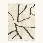 Full view of the Tazla ivory and forest green Beni Ourain rug with a branch line design.