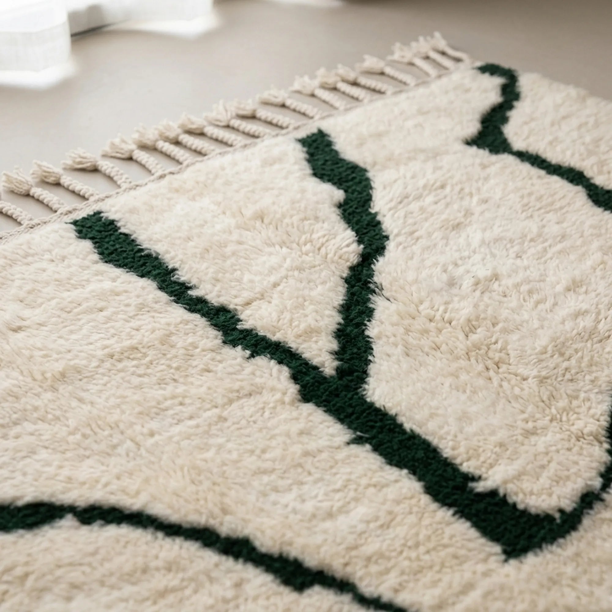 Close-up of the natural Atlas wool pile on the Tazla ivory and forest green Beni Ourain rug.