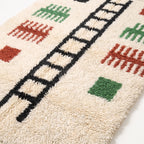 Close-up detail of pile showing hand-knotted wool texture, black ladder lines, terracotta and green comb motifs
