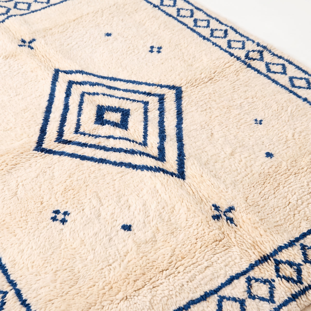 Concentric diamond motif and scattered cross pattern, close-up of pile texture