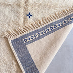 Pile texture and fringe edge showing thick wool construction and navy patterning