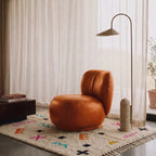 Ivory Azilal rug with symbol scatter pattern styled in a modern living room with terracotta chair, arc lamp and minimal decor