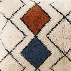 Side view of the Taziri Moroccan pillow showing its ivory and multicolor wool pile