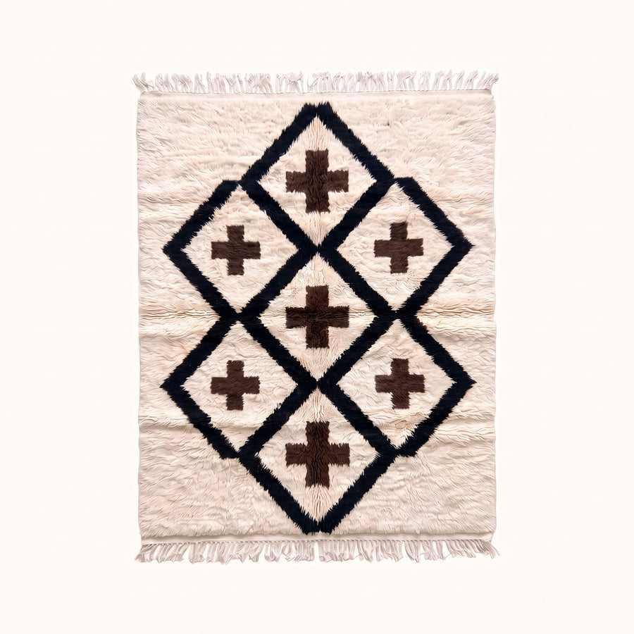 Full flat view of ivory Beni Ourain rug with black diamond lattice and brown cross motifs, fringed edges