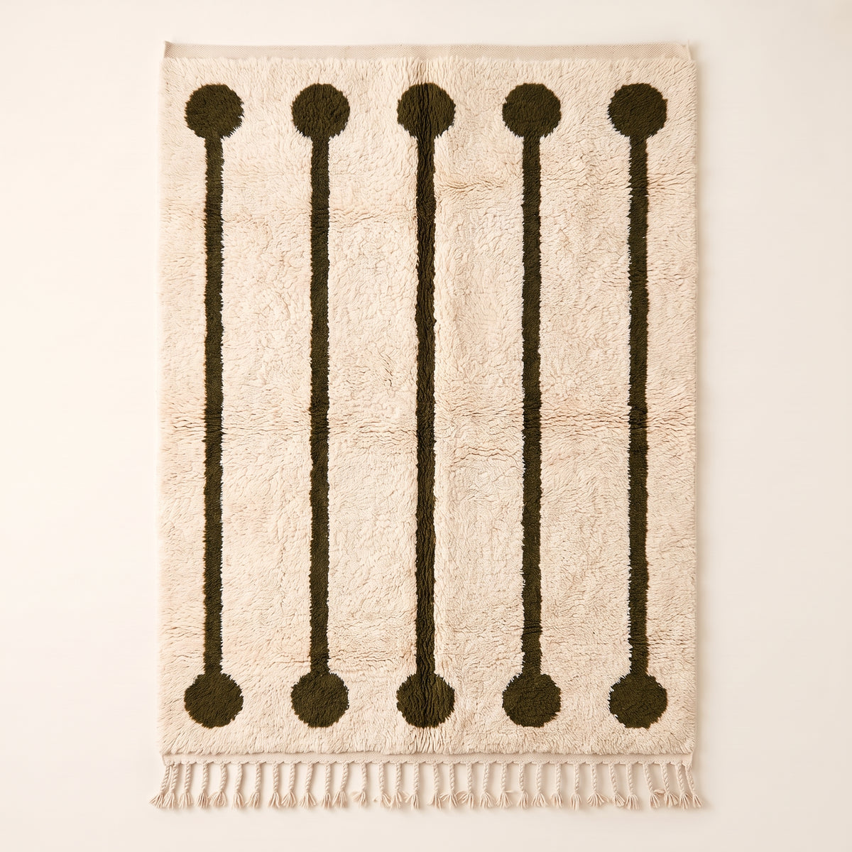 Ivory and olive Beni Ourain rug with five lollipop rail motifs featuring dark olive circles at top and bottom connected by thin vertical rails on cream ground, flat lay on plain background