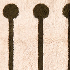 Close-up texture of ivory and olive Beni Ourain rug showing hand-knotted wool pile and lollipop rail construction