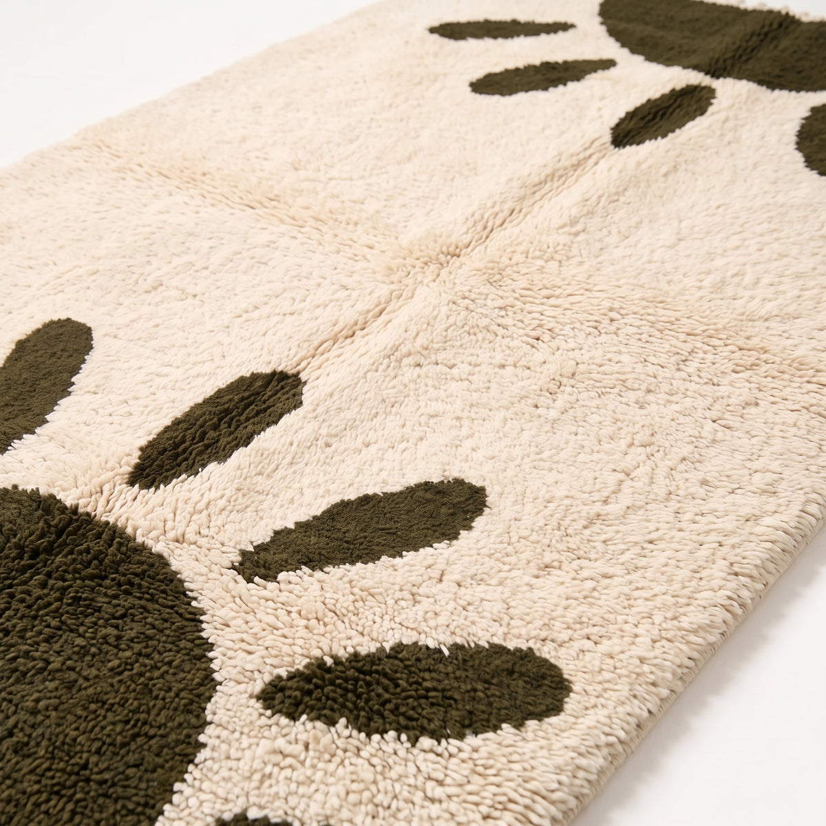 Close-up of thick knotted pile and olive ovals on ivory ground