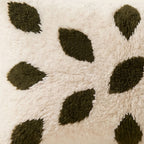 Side view of the Ijjeg Moroccan pillow showing its ivory and olive wool pile