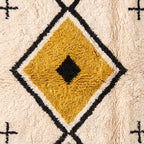Close-up of central gold diamond with black center motif and thick cream outlines showing knotted construction