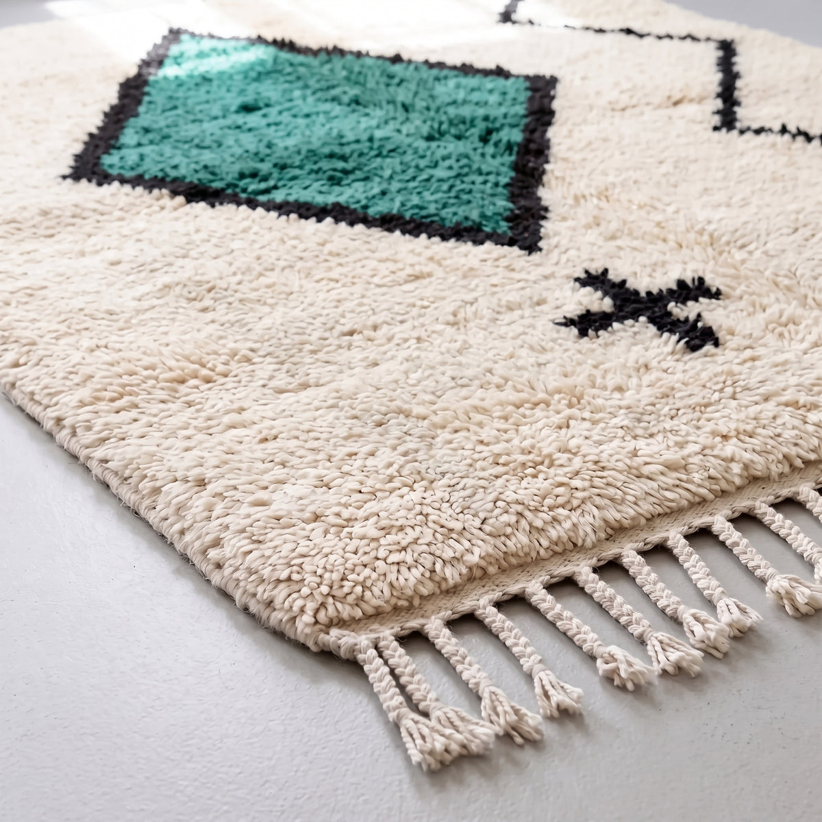 Angled view of teal diamond section with dense wool pile and black outline detail