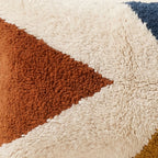 Side view of the Tagant Moroccan pillow showing its ivory, rust and navy wool pile