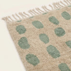 Close-up of the natural Atlas wool pile on the Taddart ivory and sage green Beni Ourain rug.