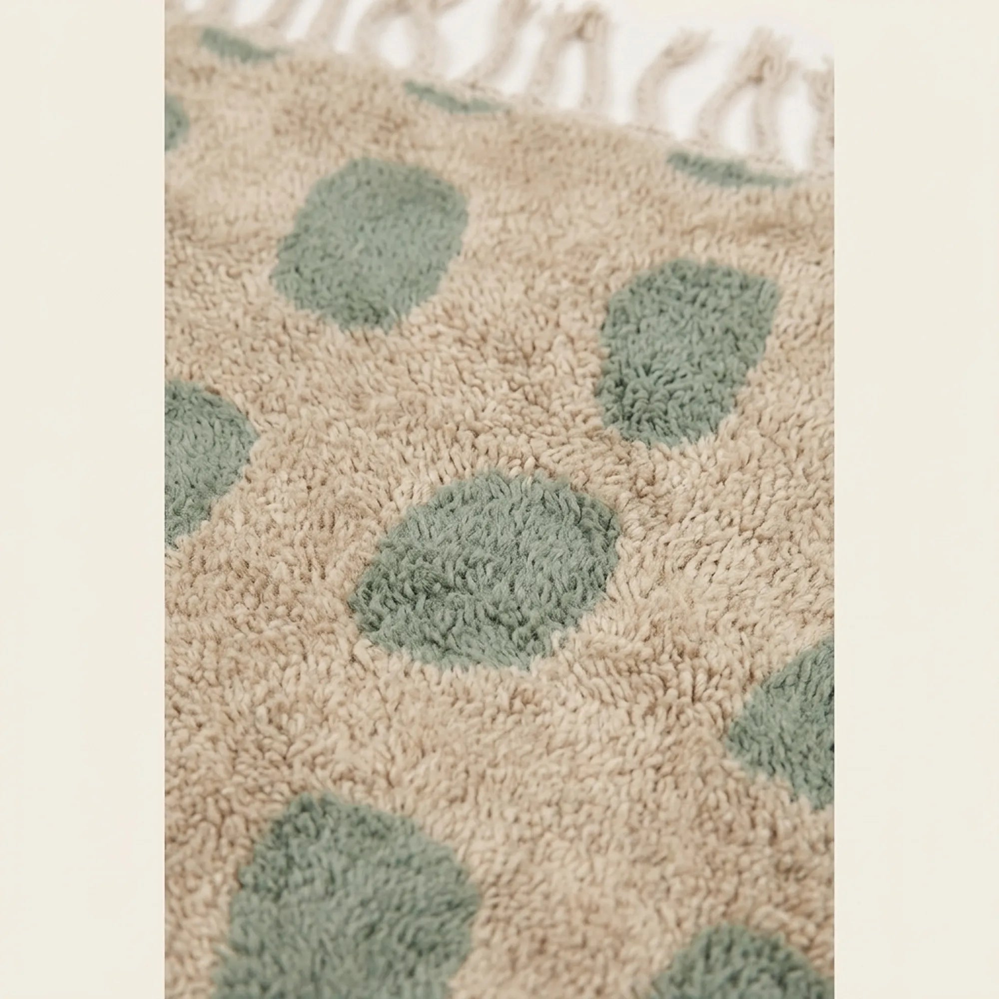 Fringe and edge detail of the Taddart ivory and sage green Beni Ourain rug.