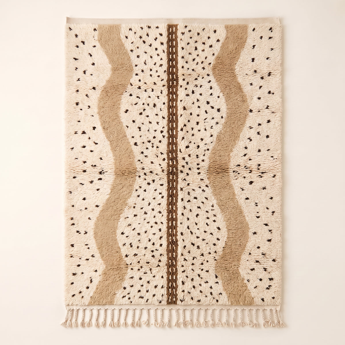 Ivory and tan Beni Ourain rug with scattered black diamonds and warm tan vertical panels with brown center band, flat lay on neutral background