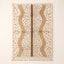 Ivory and tan Beni Ourain rug with scattered black diamonds and warm tan vertical panels with brown center band, flat lay on neutral background